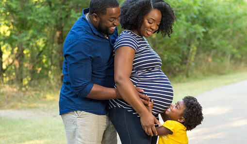 african-american-father-and-son Black dad with pregnant mom and toddler. Toddler is hugging mom and her tummy.